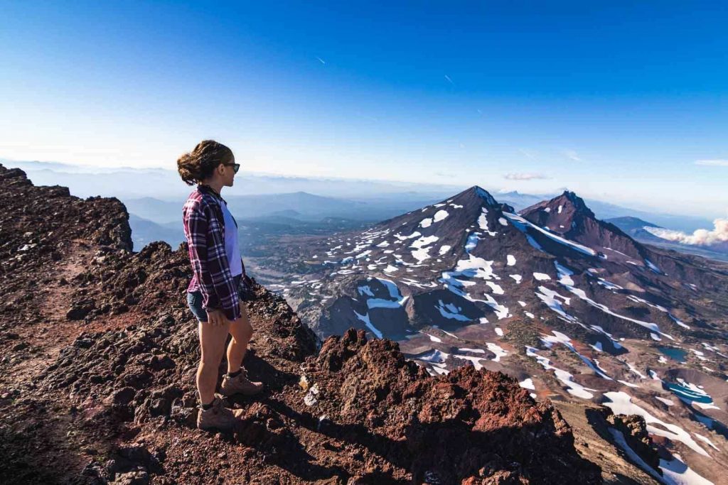 Nina looks out over snowy mountains from South Sisters hikes