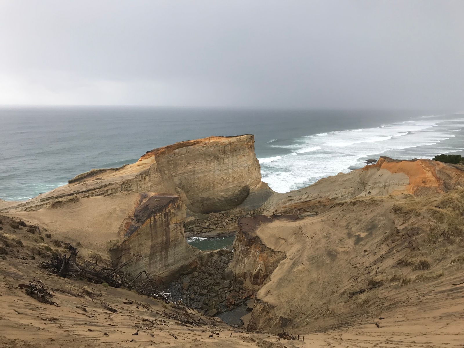 Unreal view at Pacific City, with ocean in the back and sand dunes and cliffs in the forfront.