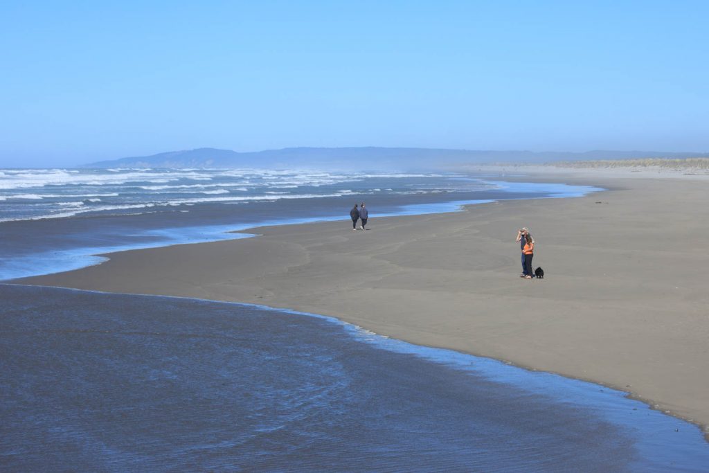 People walking on sand at Bullards Beach State Park