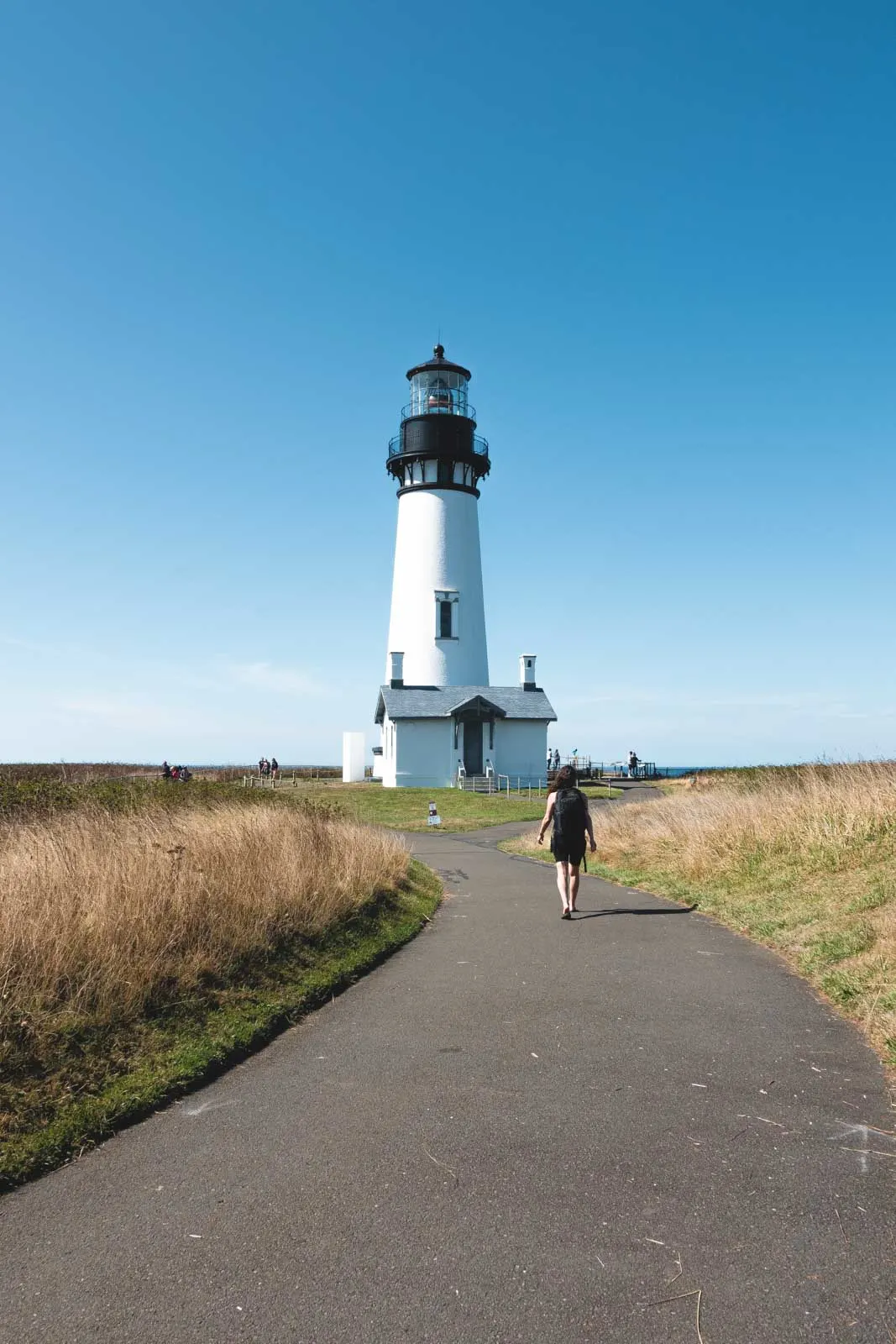 Yaquina Head Lighthouse with person walking path towards it