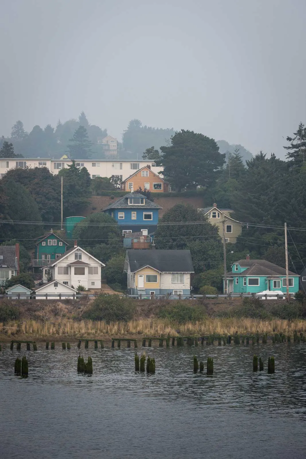 Bayfront houses in the fog with water in foreground