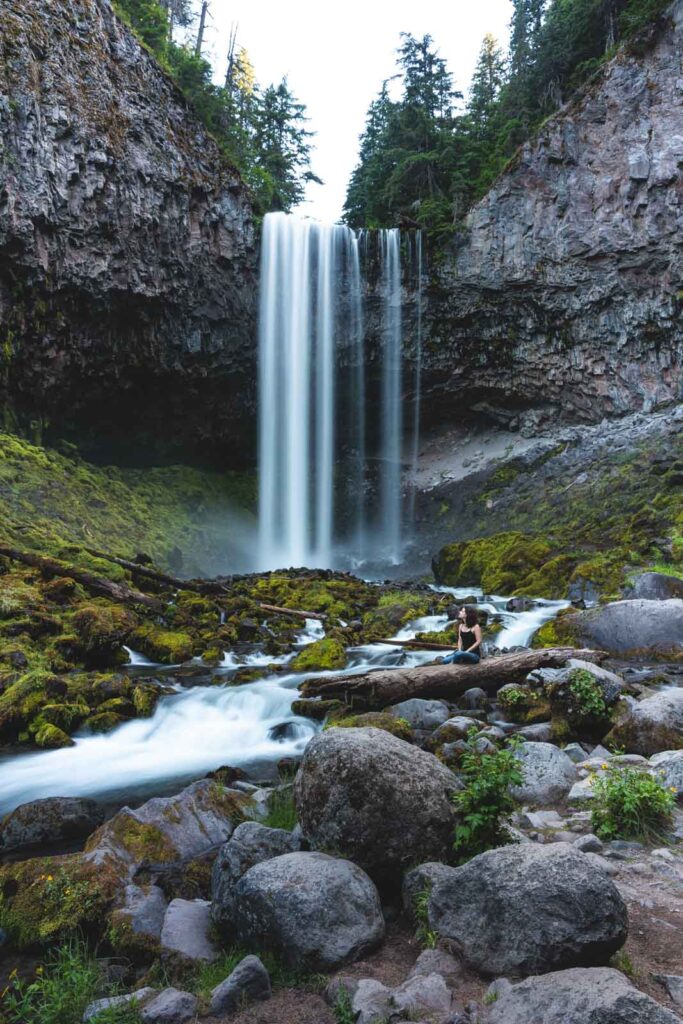 Hiker looking up at Tamanawas Falls in Oregon