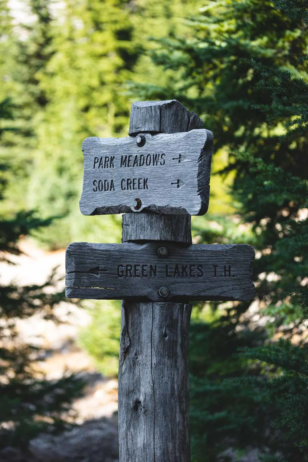 Wooden hiking directions sign on the Green Lakes trail