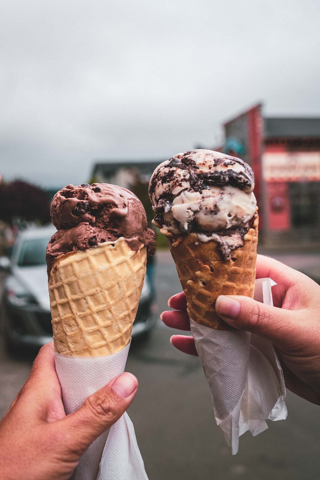 Two ice cream cones being held up in Seaside, Oregon