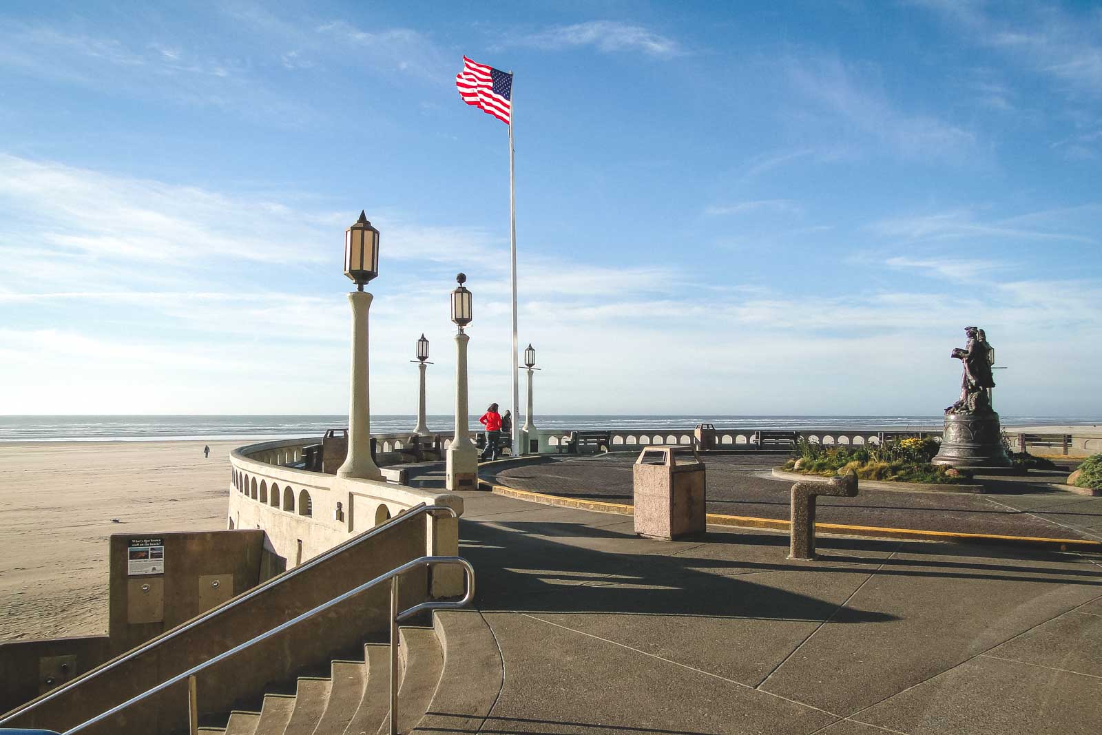 American flag and lamp posts on beach promenade in Seaside, Oregon.
