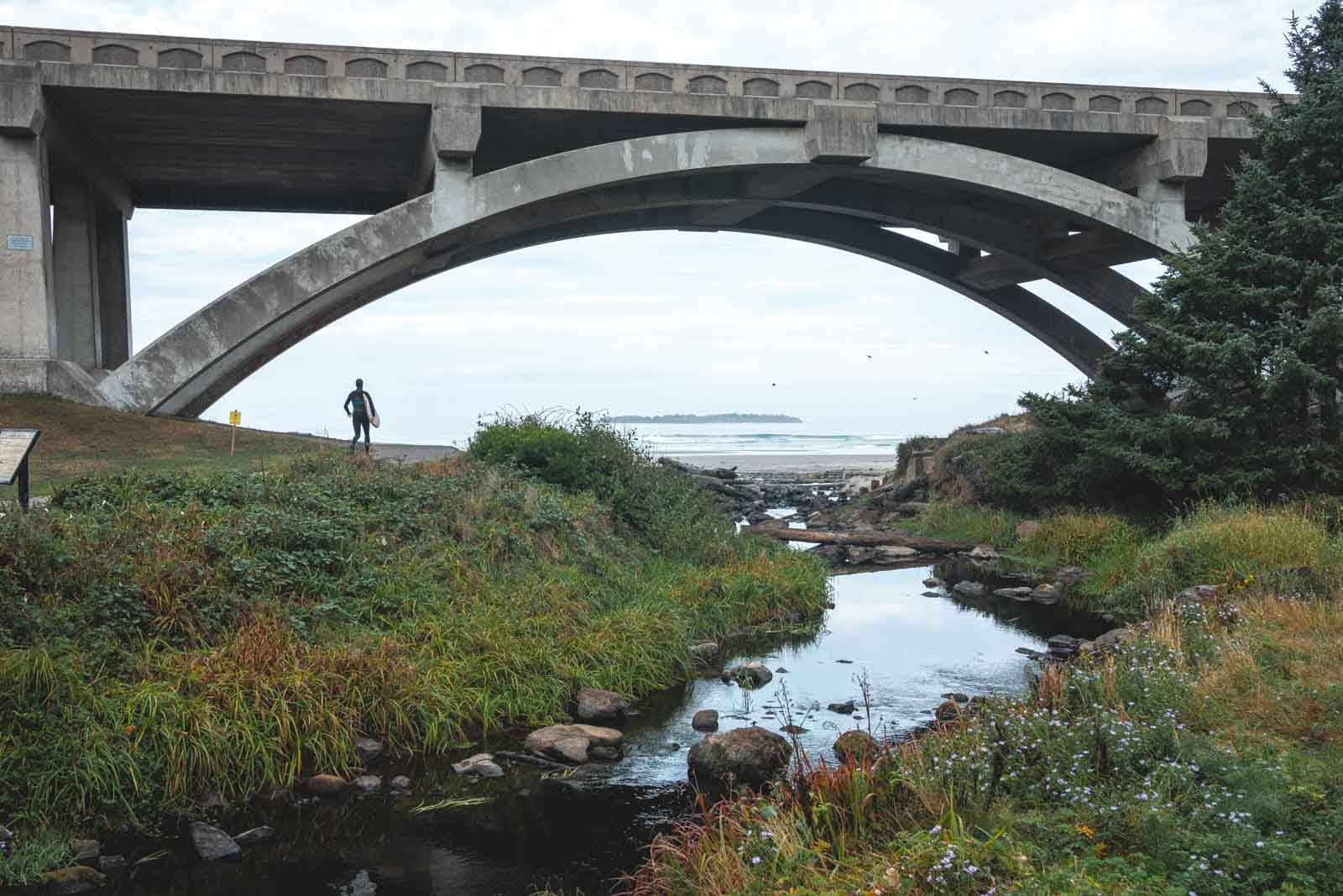 Person standing under bridge with ocean in background at Beverly Beach near Newport, Oregon.