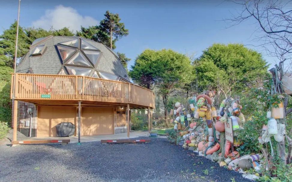Dome house with fence decorated with buoys beside it - one of the best options for glamping in Oregon