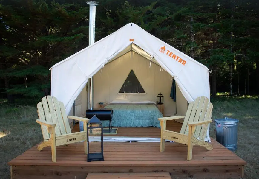 Glamping tent with chairs on deck in front at Cranberry Farms