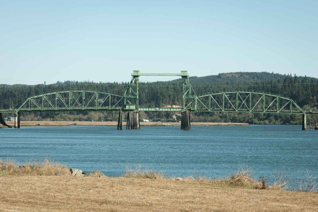 Bridge over water with forested hills in the background near Bandon Beach