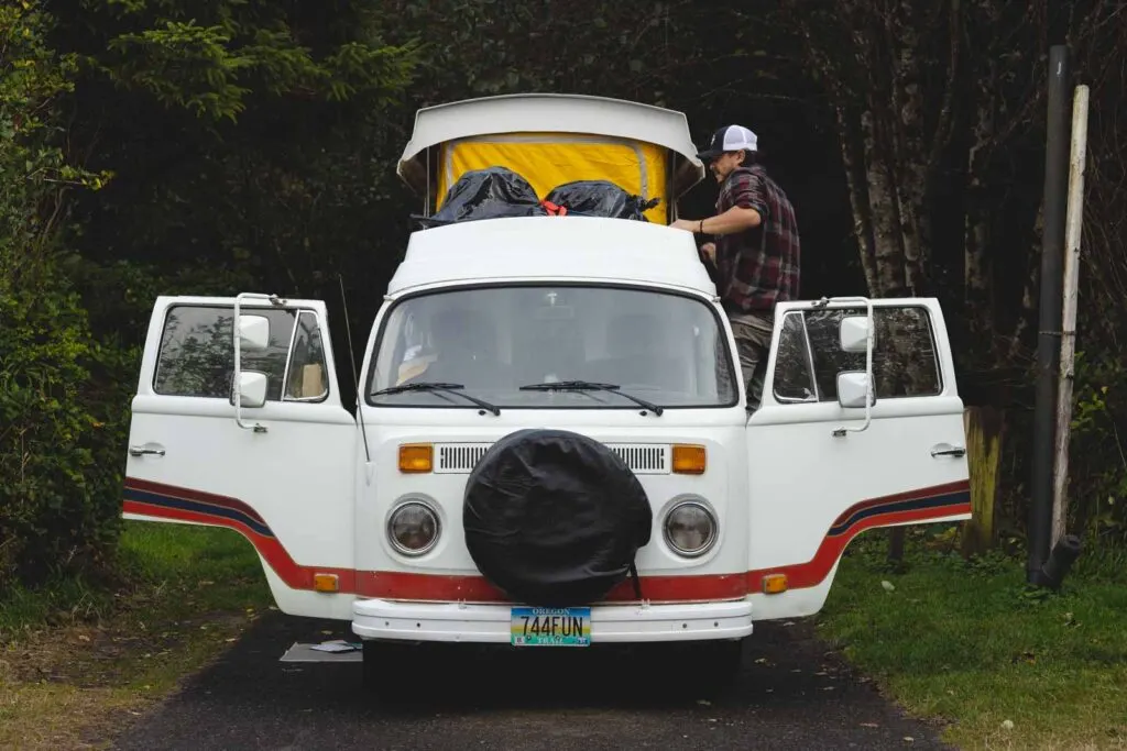 VW van wit person on the right side in the forest at Cape Lookout