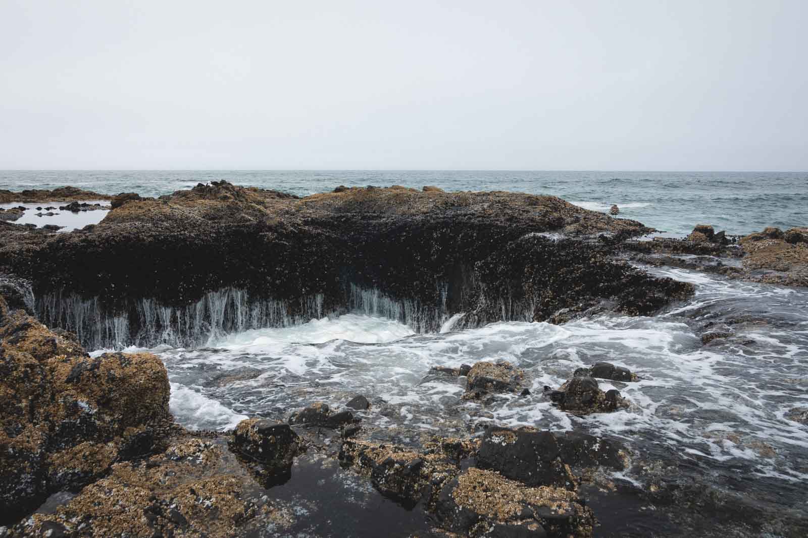 Close up shot of Thor's Well - a rocky cauldron in the ocean.