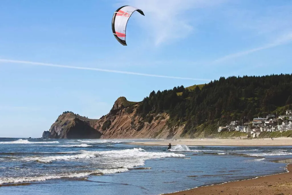 Kite surfer in waves with headland in background at Lincoln City