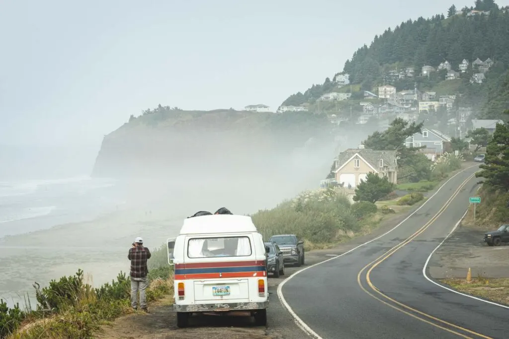 VW van with person behind it parked on the side of the road with foggy views of the beach and cape meares