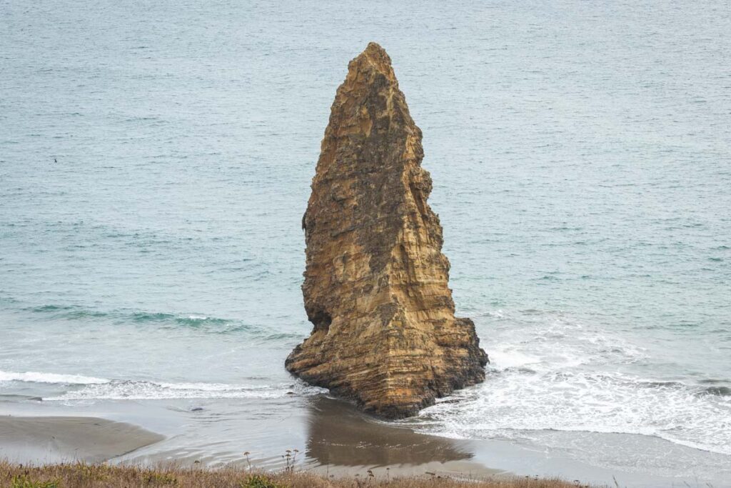 Fin shaped rock jutting out of the ocean on Cape Blanco beach
