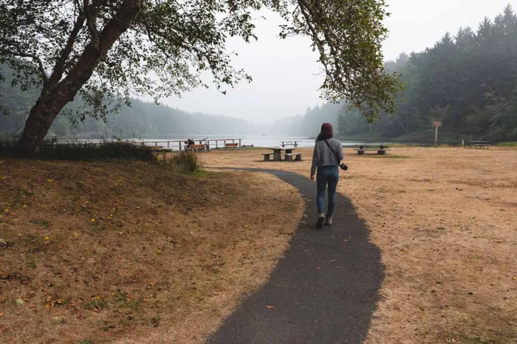 Woman walking on paved trail at Coffenbury Lake near Fort Stevens State Park