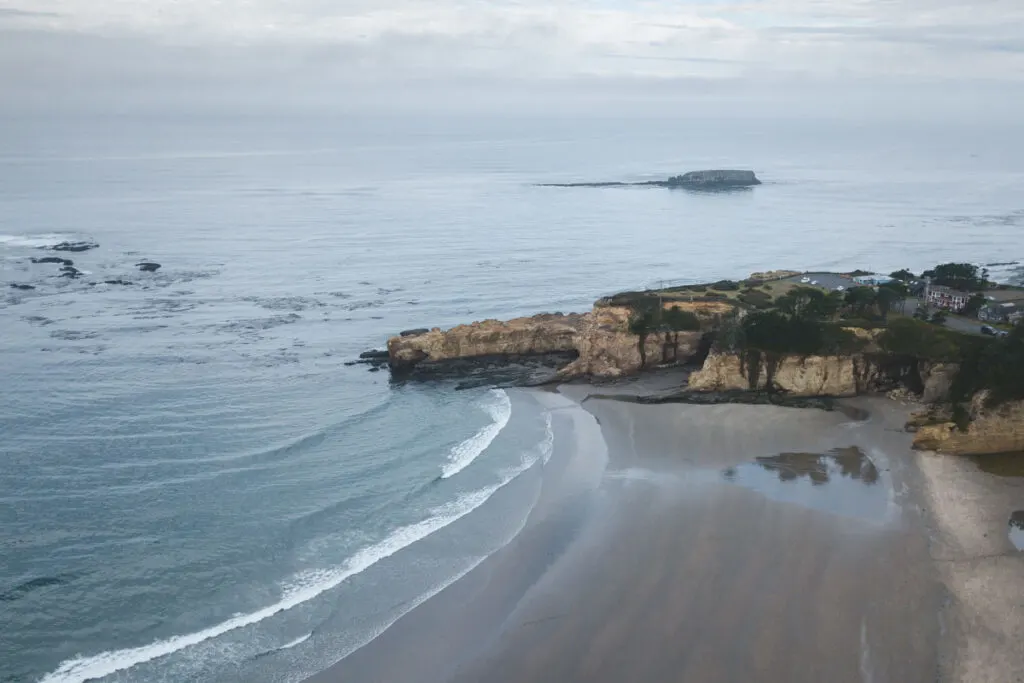 Aerial view over beach, rocky headland and ocean at Otter Rock - an Oregon surf spot