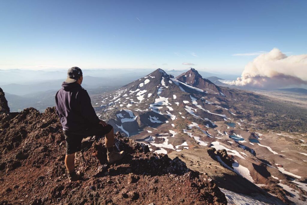 Hiker admiring the view from the summit of South Sister, Oregon