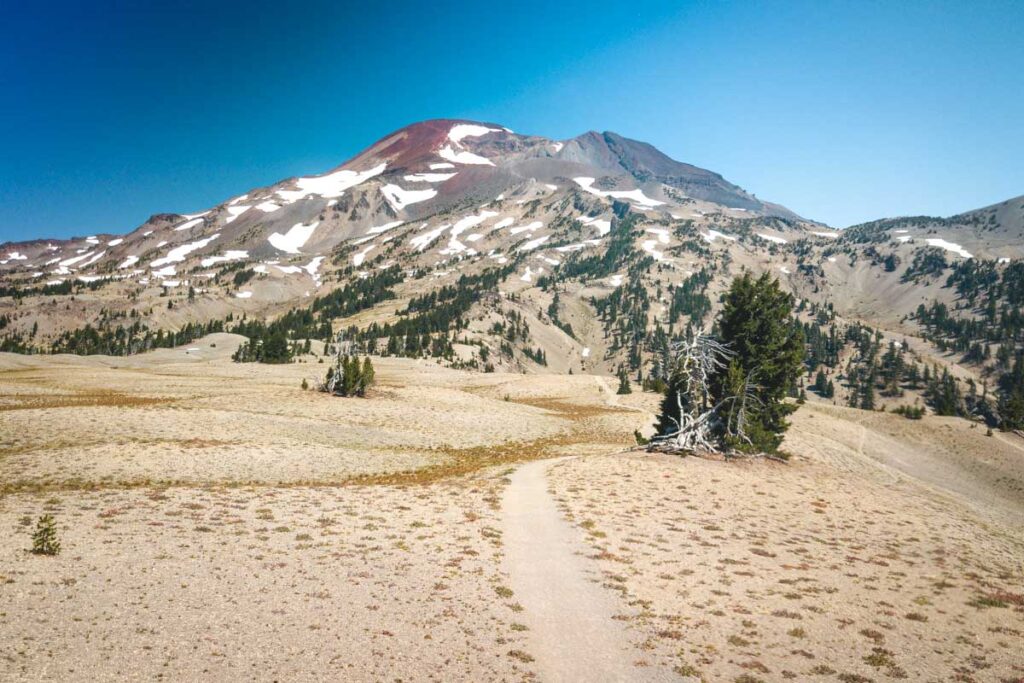 A sandy plateau with view of mountains while hiking south sister