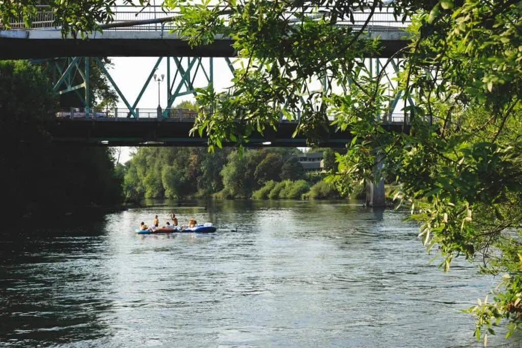 River floaters under bridge in Alton Baker Park in Eugene, Oregon