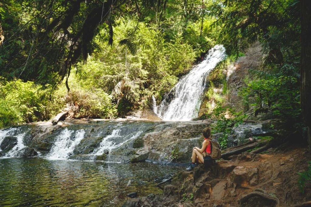 Hiker sitting at Green Peak Waterfall near Eugene