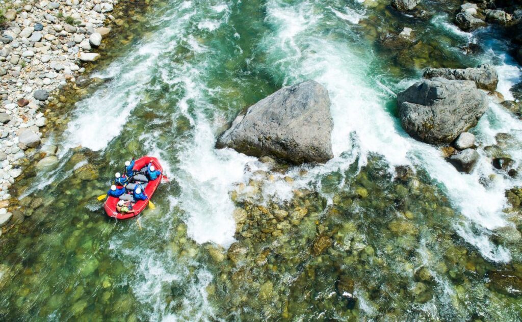 People on rocky river white water rafting in Oregon