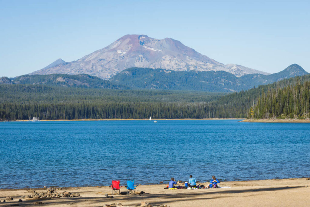 People on beach at Elk Lake with mountain in background