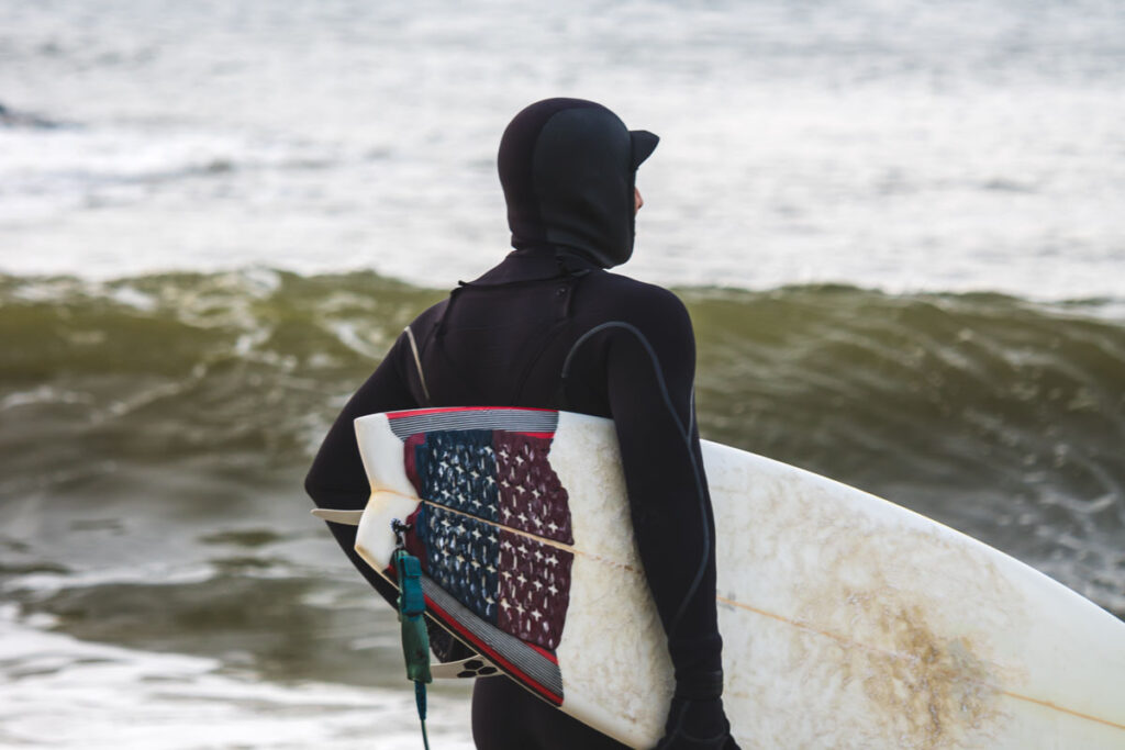Surfer wearing a cold water wetsuit and hoodie.