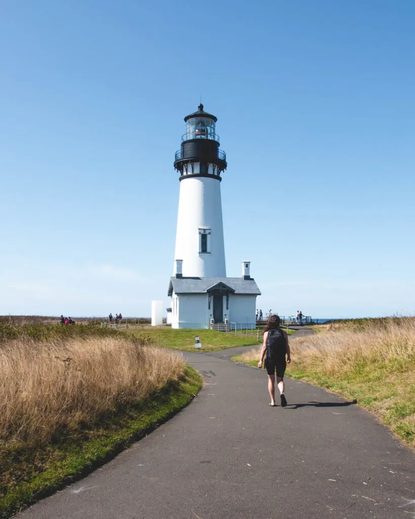Yaquina Lighthouse Trail Oregon. Nina, co-author of this blog, hiking on Yaquina Lighthouse Trail in Oregon on a summer day.