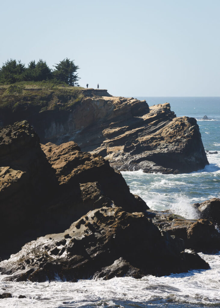Two people standing cliffside on the Cape Arago Loop Trail in Shore Acres.
