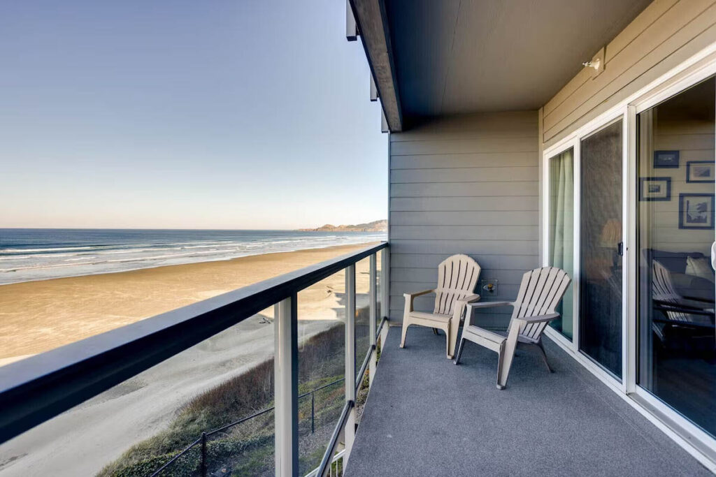Two chairs on the balcony overlooking the beach and ocean at the Nye Beach Condo in Newport.