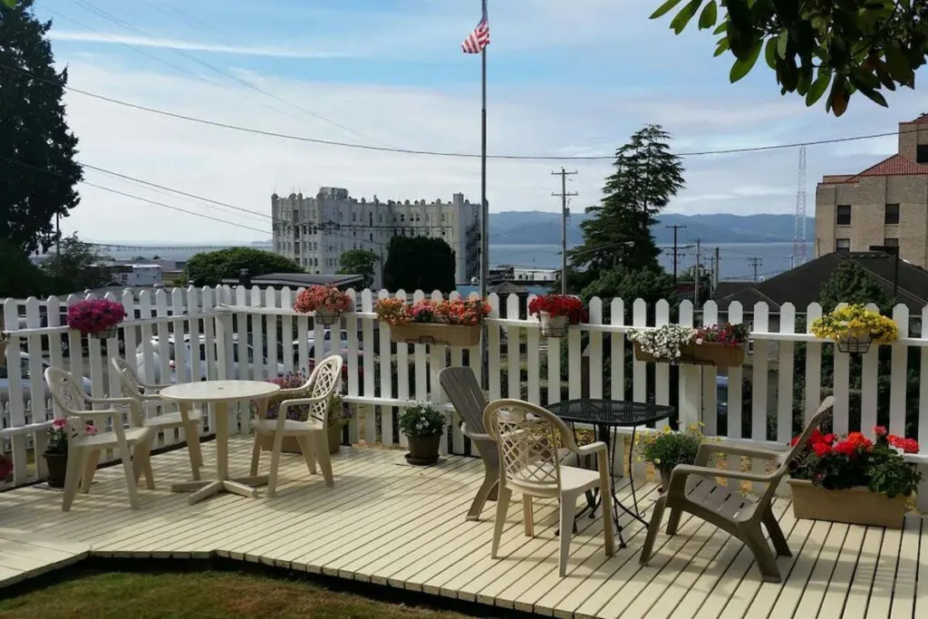 Two outdoor tables set up on the patio area of the Rose River Inn with the river in the distance. Two outdoor tables set up on the patio area of the Rose River Inn with the river in the distance.