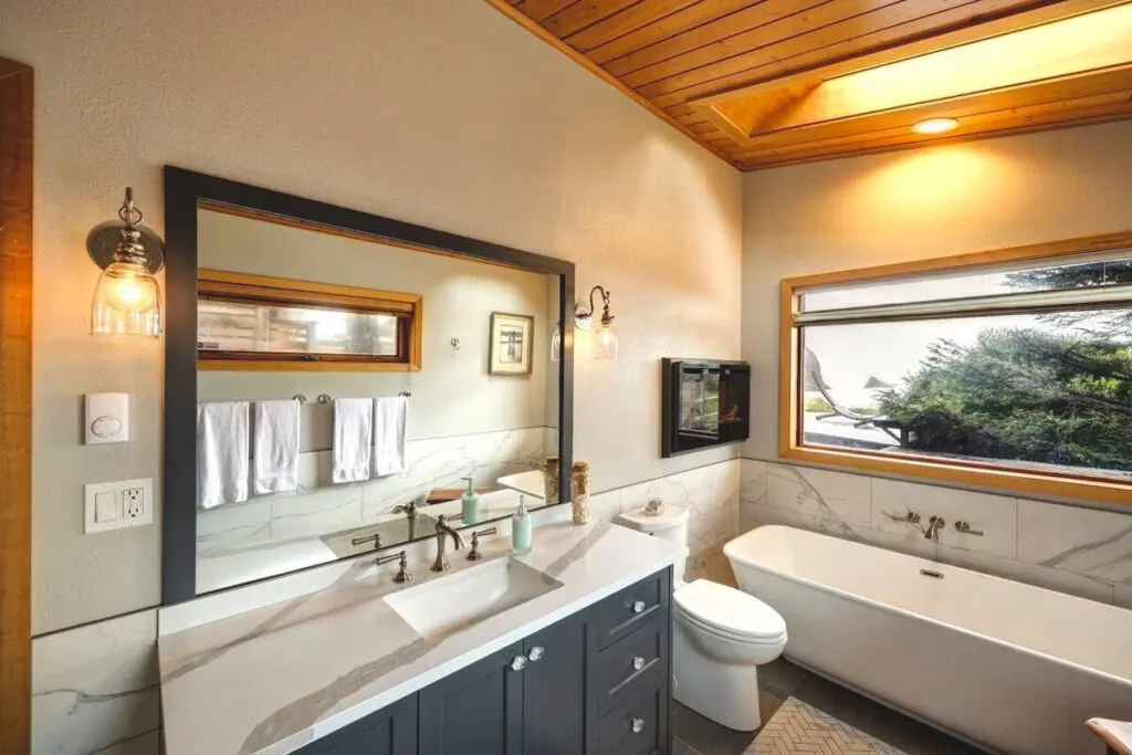 A well decorated bathroom with a view of Cannon Beach from the bathtub in the Happy Clam Oceanfront Property.