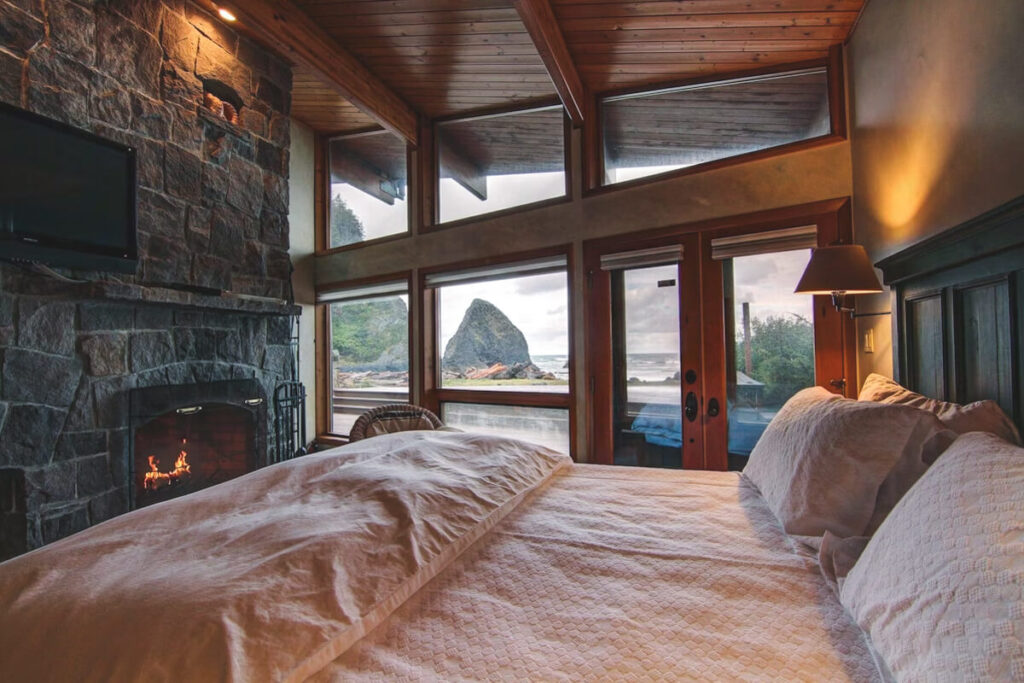 A stylish and cosy bedroom with a close view of Cannon Beach in the Happy Clam Oceanfront Property.