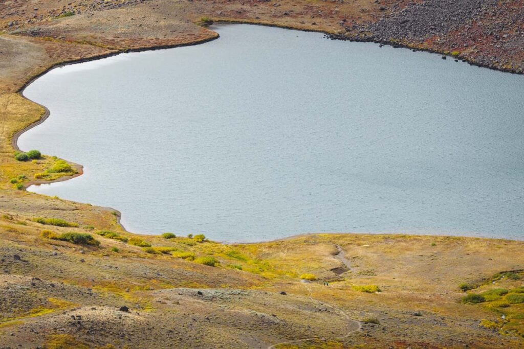 Two hikers on a Steens Mountain trail being dwarfed by the huge Wildhorse Lake.