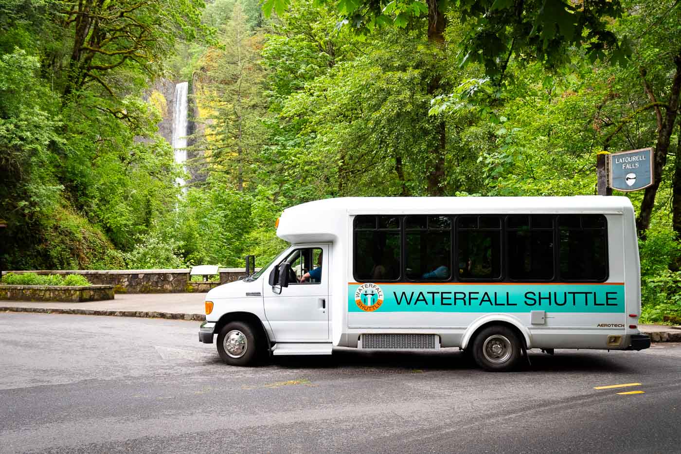 Waterfall shuttle bus with waterfall behind it.