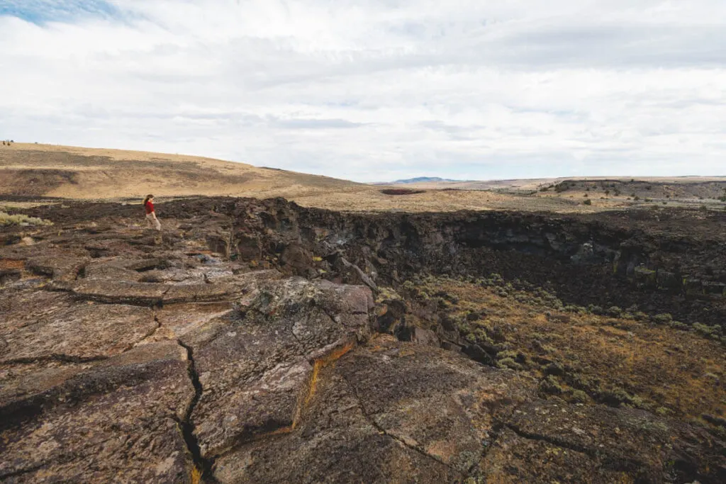 A woman overlooking Diamond Craters in Oregon.
