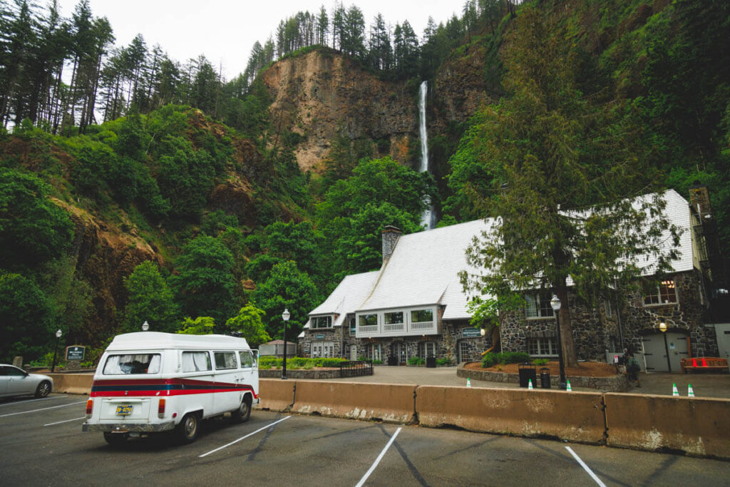 A campervan parked in one of many parking spots in front of Multnomah Falls lodge.