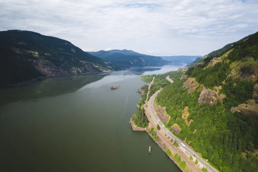 An aerial view of a highway running alongside the river in Columbia River Gorge.