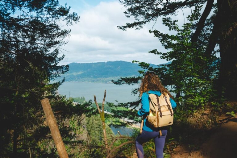A female hiker overlooks and admires a view of Columbia River Gorge in Oregon.