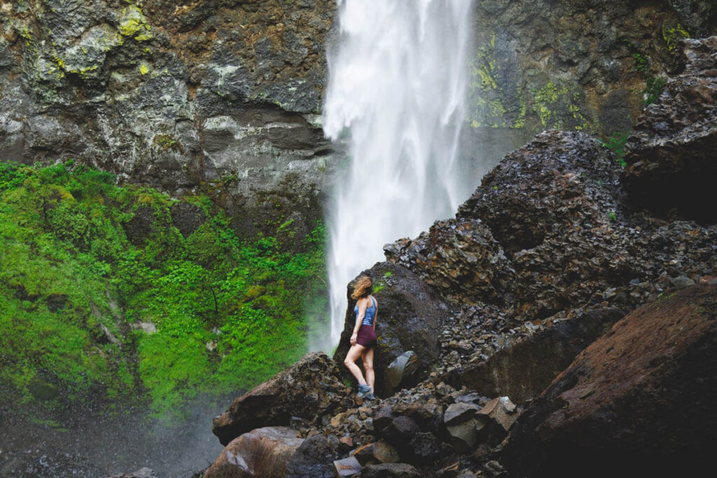 Nina standing on the rocks in front of the base of Elowah Falls.