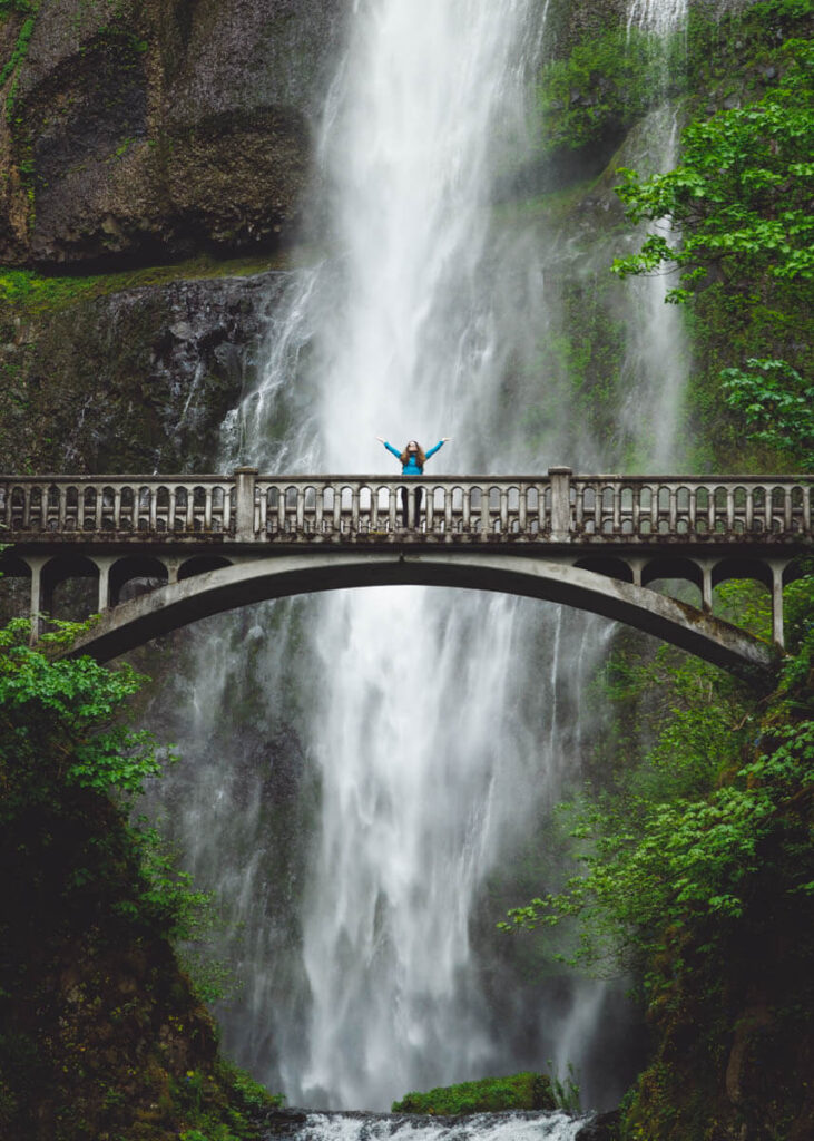 Nina posing on Benson Bridge in front of Multnomah Falls.