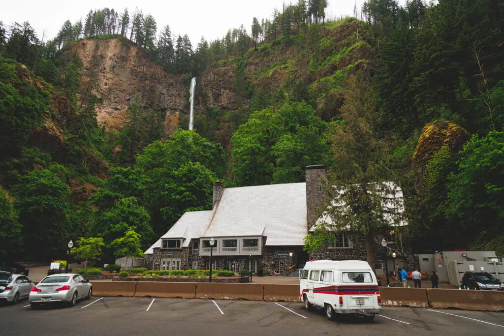 A campervan parked outside a restaurant in front of Multnomah Falls in Columbia River Gorge.