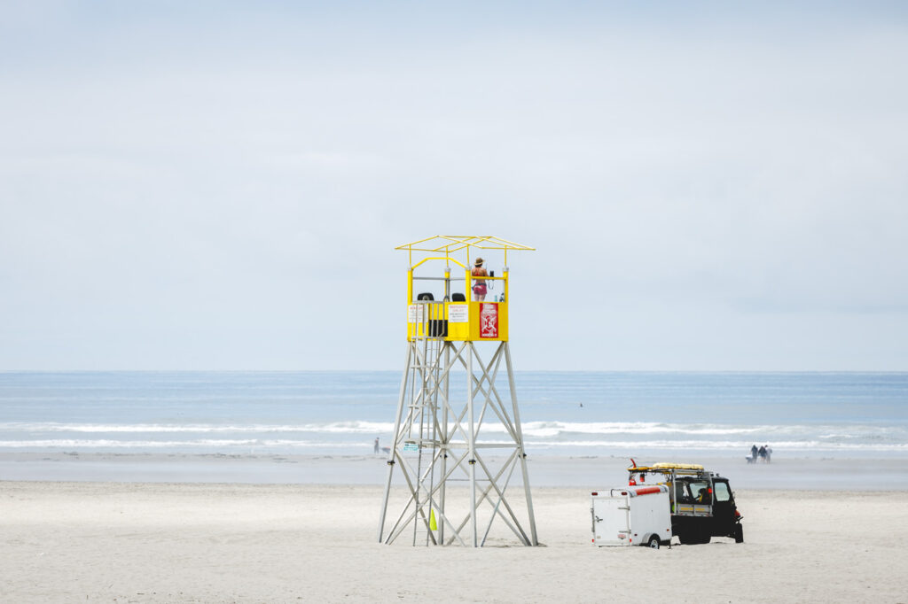 A lifeguard standing in a tower at Seaside Beach.