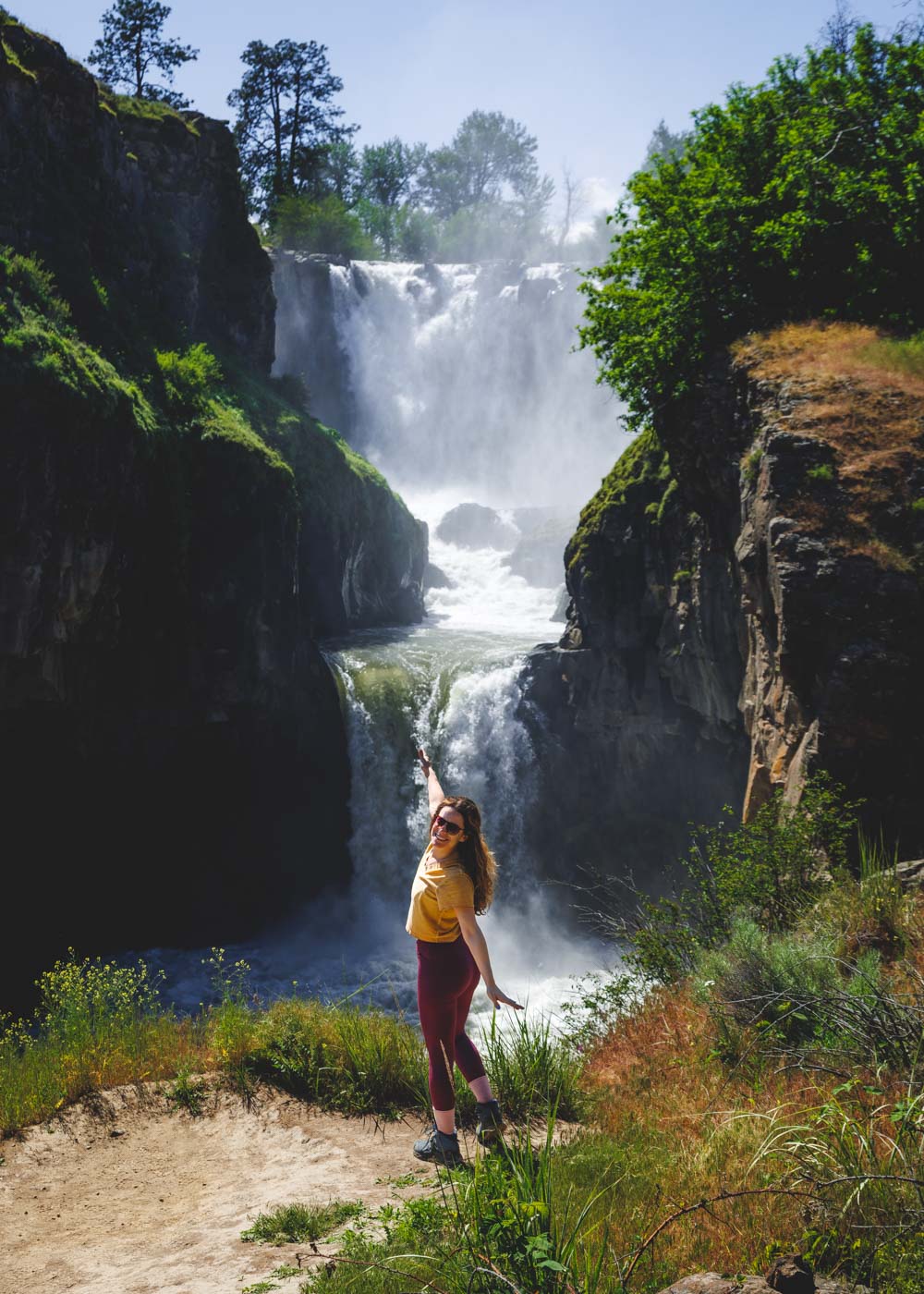 Nina posing happily in front of the two-tiered White River Falls in Oregon.