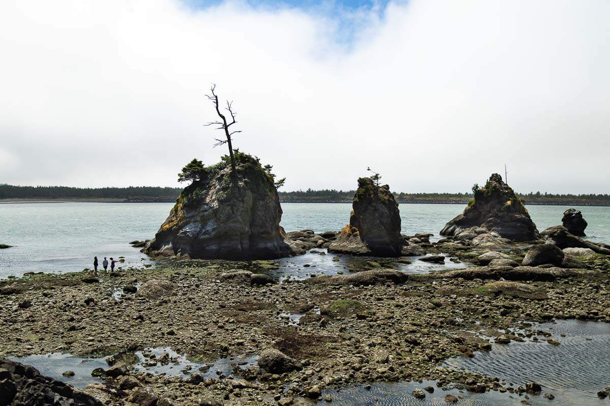 Three Graces, rocks in ocean water with group of three people to the left