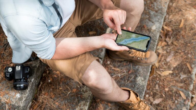 A person looking at their phone while hiking.